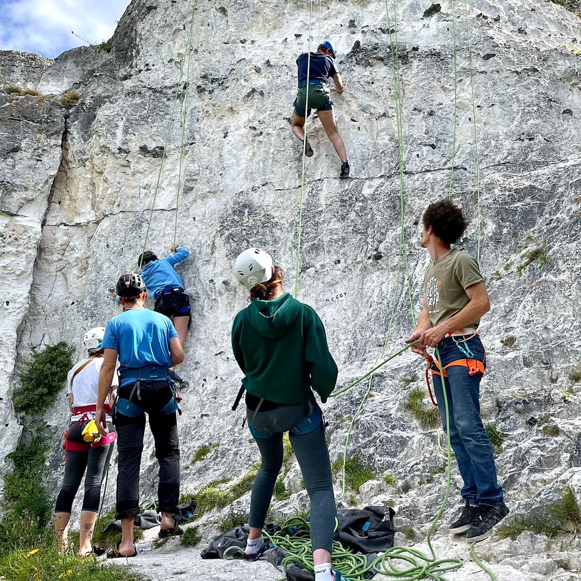 Un groupe de grimpeur apprend l'escalade en falaise